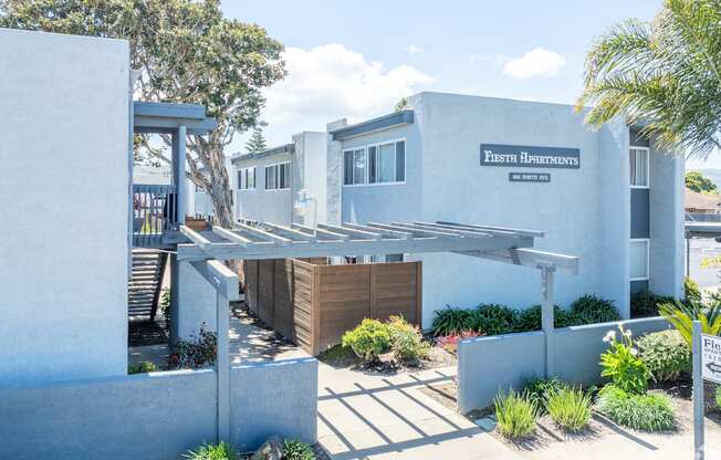 A white building with a sign that says "Fresh Apartments".