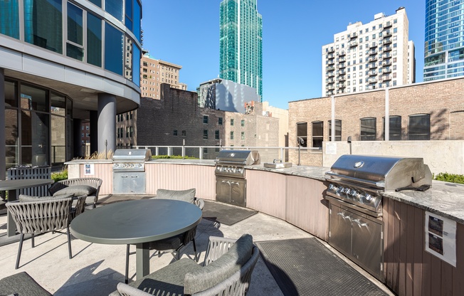 A patio with a table and chairs overlooking a cityscape.