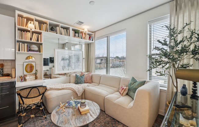 a living room with a couch and a table     and a window at Link Apartments® Broad Ave, Memphis