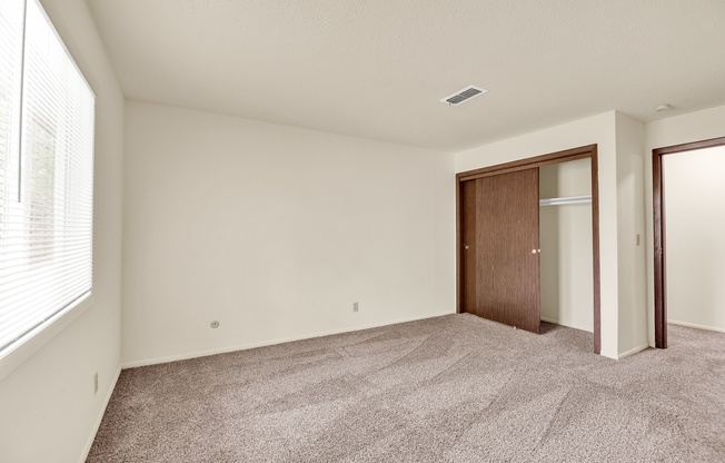 A room with a carpeted floor and a brown door.