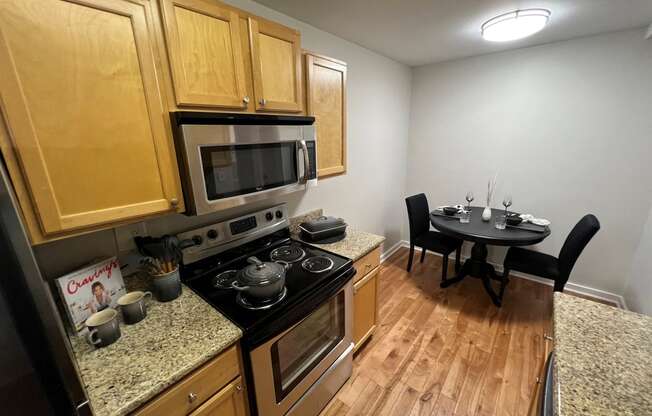 a kitchen and dining room with wood flooring and stainless steel appliances