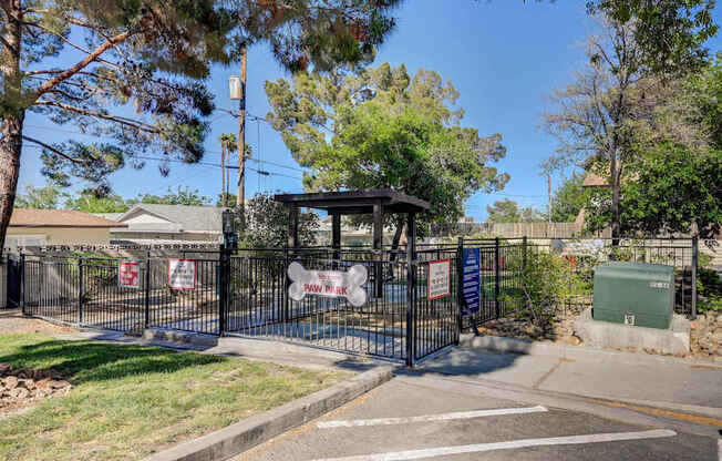 A black gate with a sign that says "No Parking" is in front of a house.