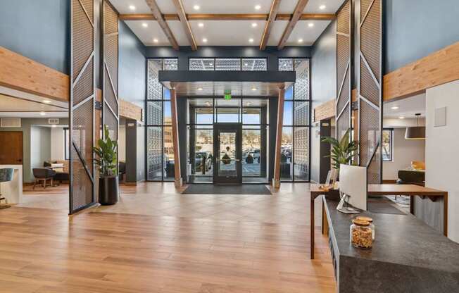 A modern lobby with wood floors and a glass wall.