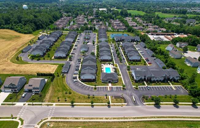 A bird's eye view of a residential area with houses and a swimming pool.