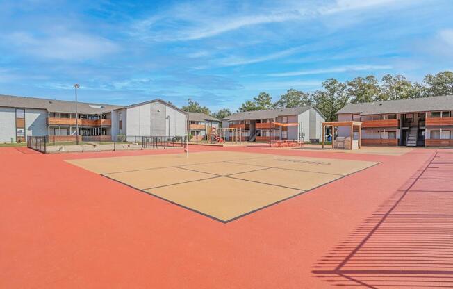 A tetherball court is surrounded by a playground, dog park, and communal barbeque area at The Marq in Shreveport, LA