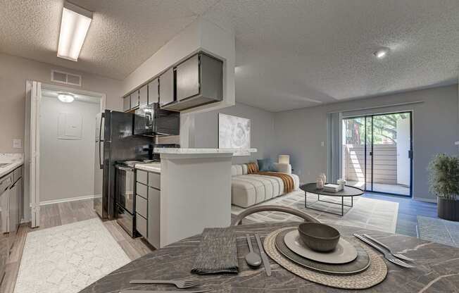 A modern kitchen with a breakfast table set up in the middle.