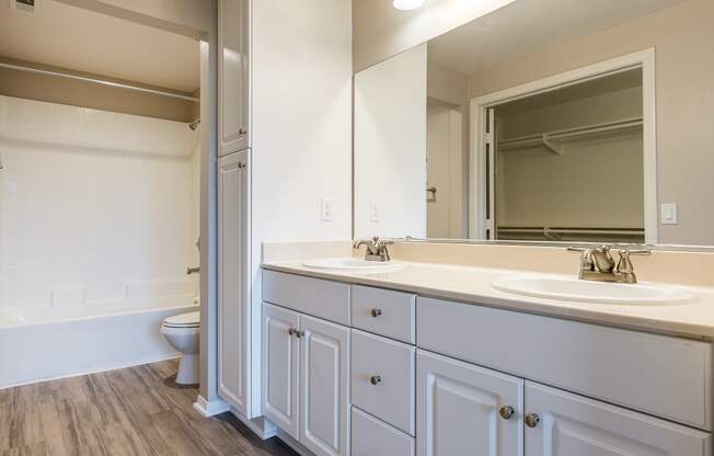 a bathroom with white cabinets and a white toilet