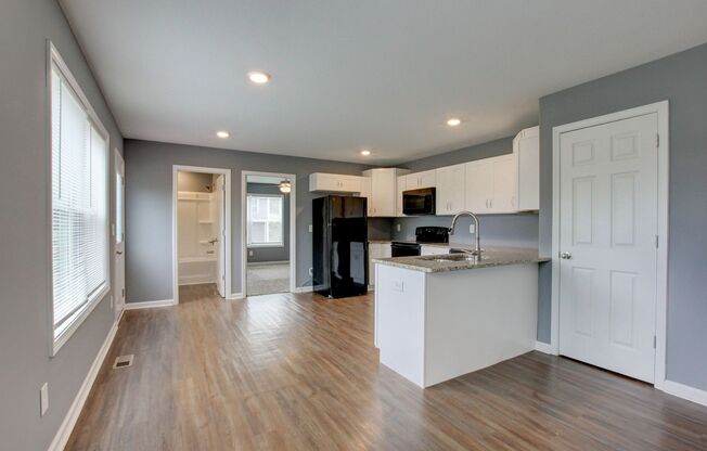 Two Story Duplex With Hardwood Flooring and White Cabinetry