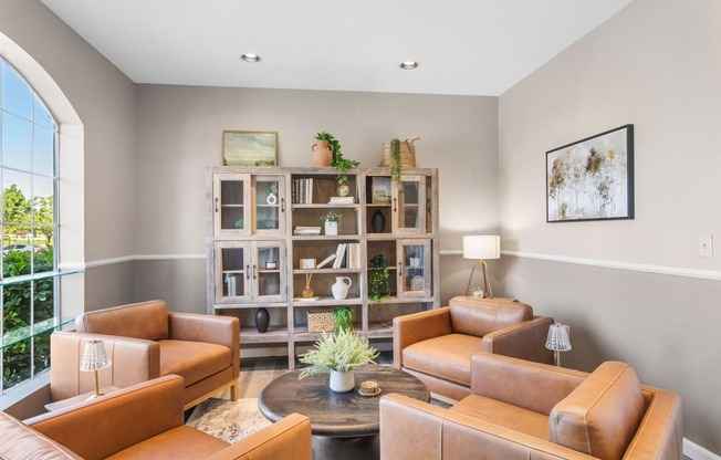 a living room with brown leather furniture and a bookshelf