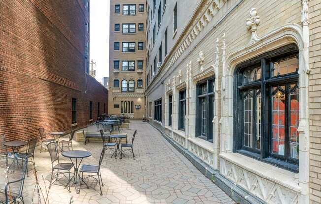 a courtyard with tables and chairs on the side of a building