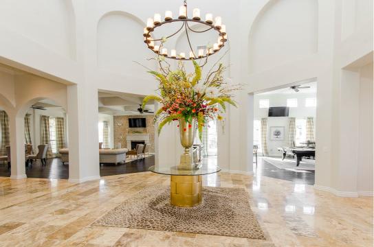 A large, elegant room with a central floral arrangement on a pedestal.