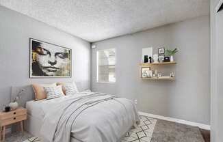 A bedroom with a bed, nightstand, and a painting on the wall.