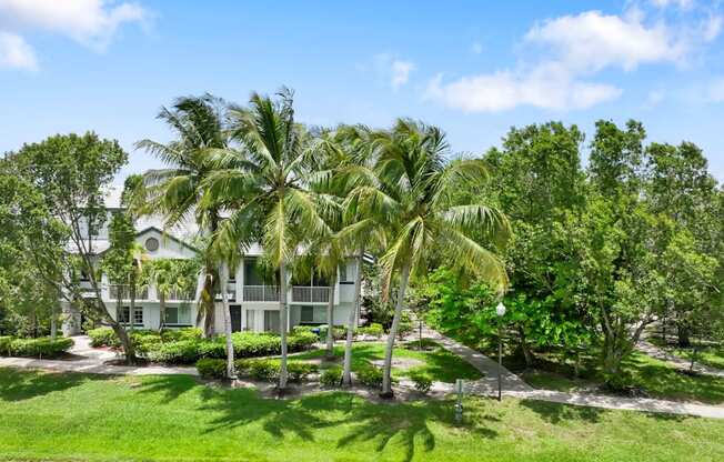 a white house with palm trees in front of it