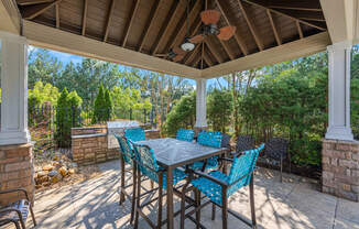 a covered patio with a dining table and chairs