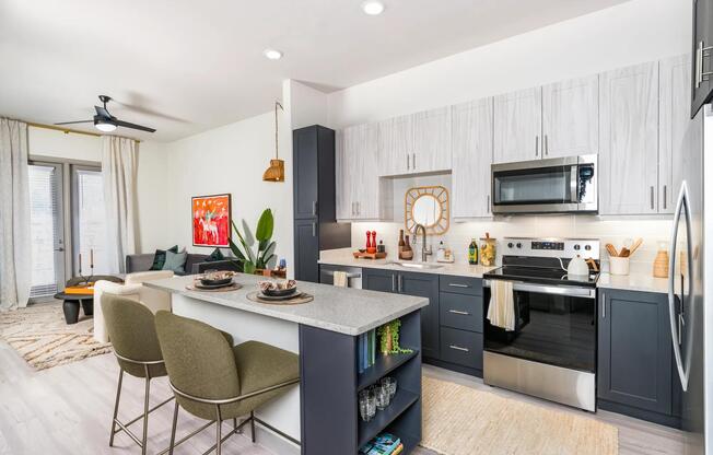 Elevate your culinary skills in our modern kitchen, featuring quartz counter tops, shaker white cabinets with satin pulls, and stainless steel appliances.