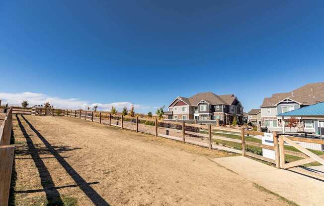 A row of houses with a fence in front of them.