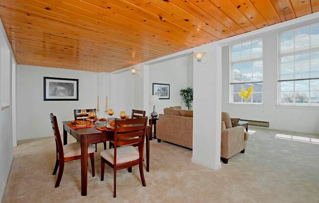 a dining room with a wooden ceiling and a table and chairs at Tindeco Wharf, Baltimore Maryland