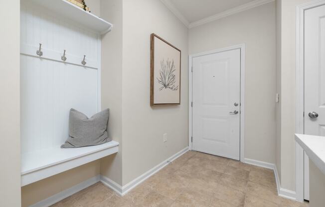 a bathroom with a white door and a shelf with a pillow