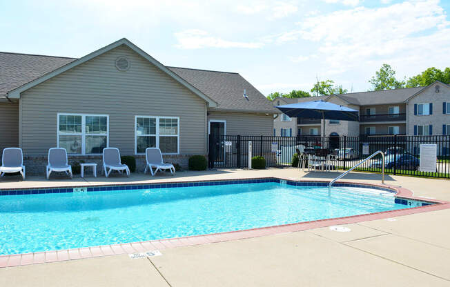 Outdoor pool located next to the clubhouse with lounge chair seating