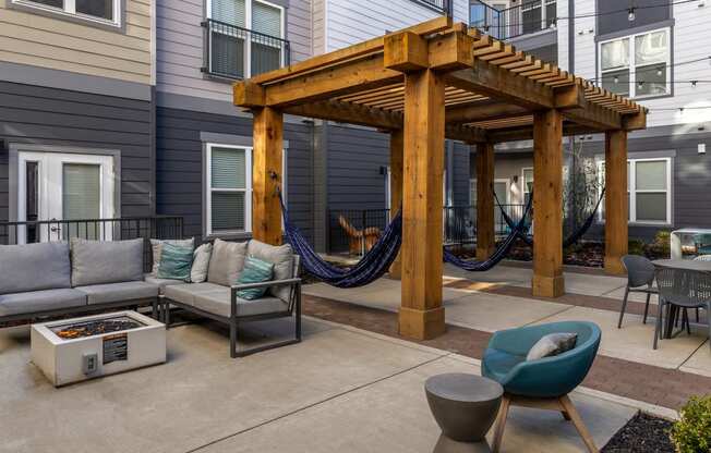 a patio with hammocks and couches in front of a house