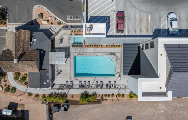 an aerial view of a building with a pool and a parking lot