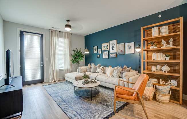 a living room with a blue accent wall and a white couch