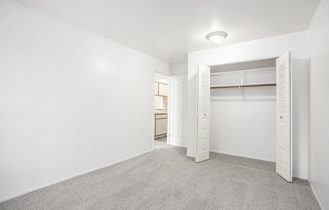 a bedroom with a closet with open doors at Hampton Lakes Apartments, Michigan, 49534