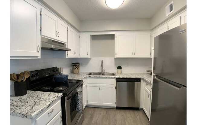 A kitchen with white cabinets and a black stove top oven.