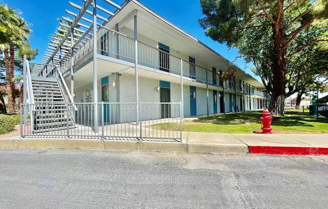A white building with a red fire hydrant in front of it.