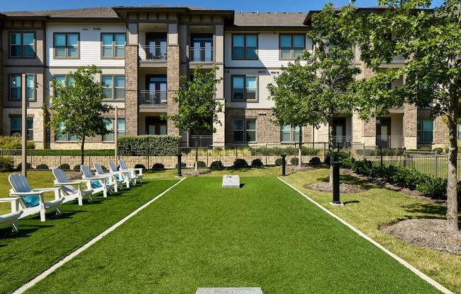 A grassy area in front of a building with a sign that says