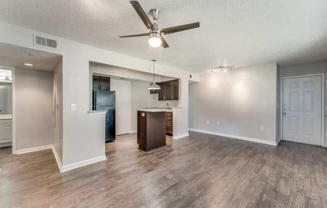 an open living room and kitchen with a ceiling fan