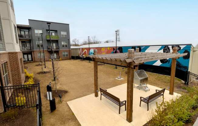 a courtyard with benches and awning in front of apartment buildings