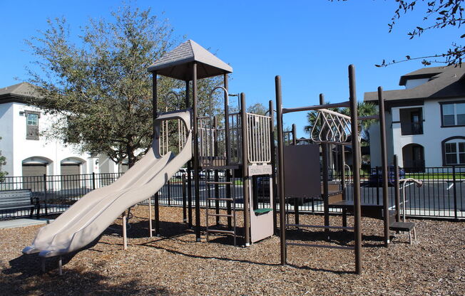 Modern Playground equipment in fenced in playground in Orlando, FL 32827