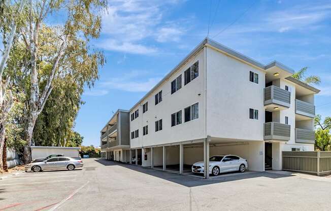 A white building with a car parked in front.
