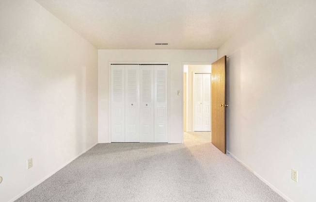 an empty bedroom with a large closet