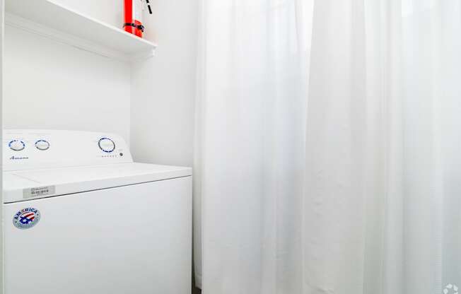 A white washing machine with a blue and white sticker on it.