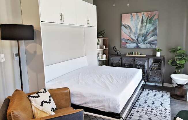a bedroom with a bed and a chair and a bathroom at GrandView Flats and Townhomes, Granger