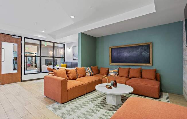 A living room with a couch, a coffee table, and a painting on the wall.