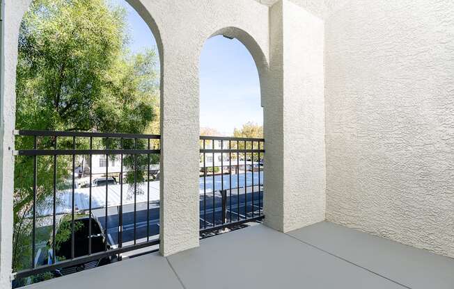 a balcony with a view of a pool and trees