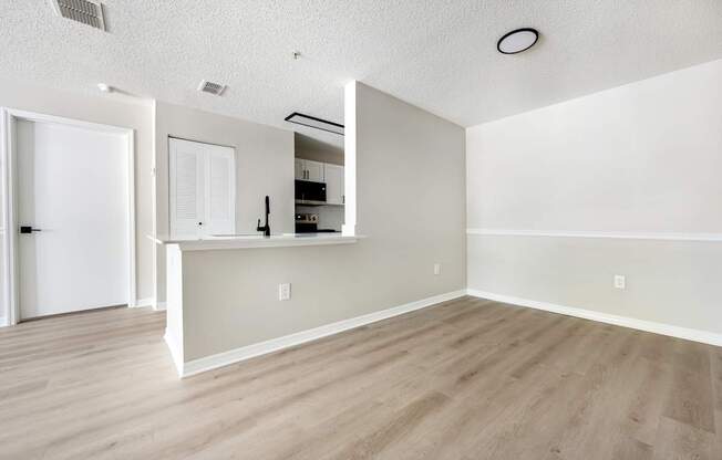 A white room with a bar counter and a fridge.