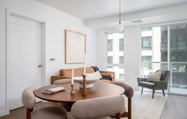 a living room with a table and chairs and a large window at Slabtown Square Apartments, Portland , Oregon