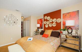 a bedroom with a bed and desk in a room