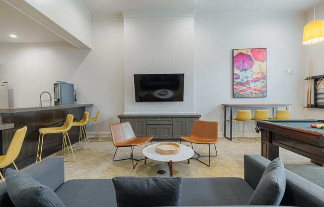 a living room with couches and chairs and a pool table