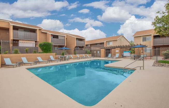 A large swimming pool in front of apartment buildings.