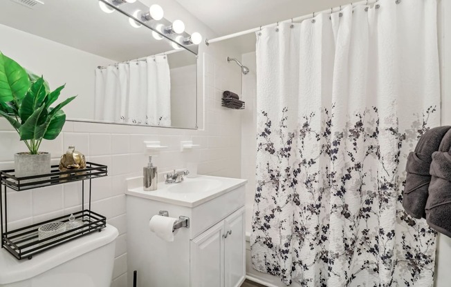 a white bathroom with a shower curtain and a sink