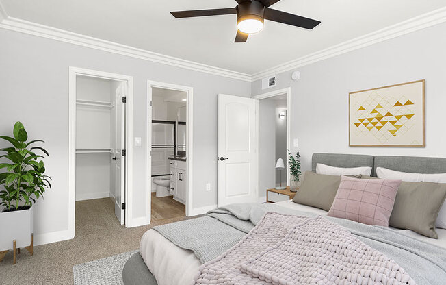 Carpeted bedroom with ceiling fan and private bathroom.