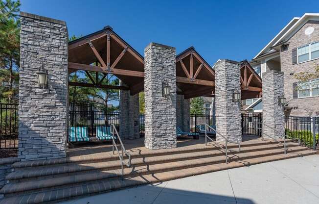 a pavilion with steps and a pool in front of a building