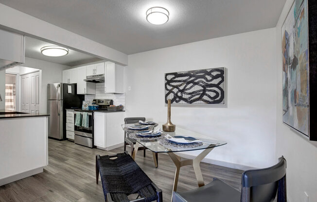 a kitchen and a dining room with a table and chairs