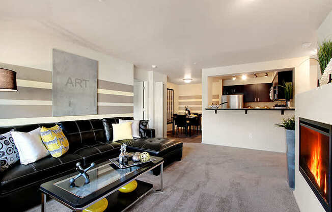 A modern living room with a black couch and a fireplace. at Mill Creek Meadows Apartments, Mill Creek, WA, 98012