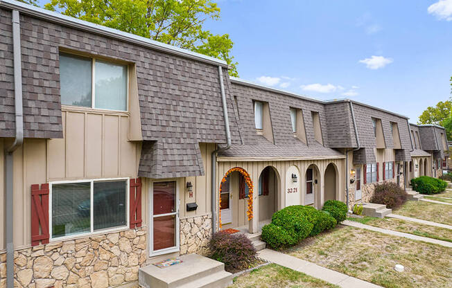 a group of houses in a row with a sidewalk and grass